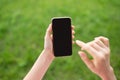 Girl using modern mobile phone with touch screen against green unfocused background.