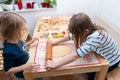 A girl is using the rolling pin to roll out the dough on the tab Royalty Free Stock Photo