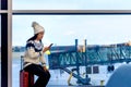 Girl using phone and sitting on suitcase at the airport Royalty Free Stock Photo