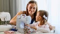 A girl is sewing on a machine. Mom shows how to work with equipment. Close-up.