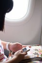 The girl using smart phone on the airplane Royalty Free Stock Photo