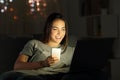 Girl using a smart phone and laptop in the night