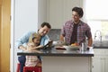 Girl using tablet computer in kitchen with her male parents Royalty Free Stock Photo