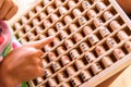 Girl using a wooden board with mathematical multiplication operations, a game to learn Royalty Free Stock Photo