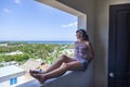 A girl on vacation on a hotel balcony looking at the resort. Young girl looking at sea over balcony Royalty Free Stock Photo