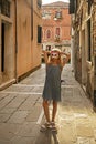 girl in a Venetian cat mask stands on a Venetian street illuminated Royalty Free Stock Photo