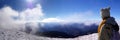 Girl view a beautiful panorama of the snow-capped mountains of the Carpathians from the top of Goverly in spring in a beautiful