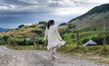 The girl in white walks on the streets of a village in the mountains on a beautiful autumn day. A very beautiful landscape Royalty Free Stock Photo