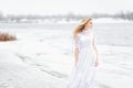 girl in a vintage dress on a river in winter