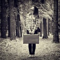 Girl with vintage suitcase and camera standing in forest and loo Royalty Free Stock Photo