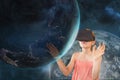 Girl in VR headset touching a 3D planet against a blue sky with planet and stars Royalty Free Stock Photo