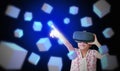 A girl with VR virtual reality goggles or glasses reaching out and touching floating virtual boxes. Metaverse technology concept. Royalty Free Stock Photo