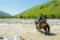 Girl wading dangerous river a on horse, Adischala river, Adishi, Svaneti, Caucasus mountains,Georgia Royalty Free Stock Photo