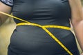 Girl waist belly fat woman with waist tape measure closeup shot