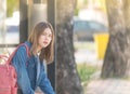 Girl wait for a bus.Bored teen waiting for parents outdoor on the metal bench sitting