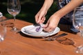 Girl the waiter in a summer cafe under the open sky sets the dishes on a wooden table