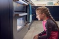 Girl Waiting By Oven In Kitchen At Home For Cakes To Bake