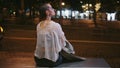 Girl waiting public transport on bench night street close up. Woman sitting bus Royalty Free Stock Photo