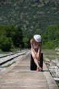 Girl waiting with rolling upright suitcase at docks