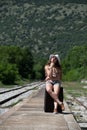 Girl waiting with rolling upright suitcase at docks