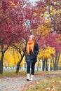 Girl walk on footpath in city park, fall season Royalty Free Stock Photo