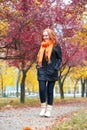 Girl walk on footpath in city park, fall season Royalty Free Stock Photo