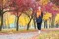 Girl walk on footpath in city park, fall season Royalty Free Stock Photo