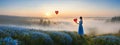 The girl walked in the Don't Forget Me flower field, looking at the heart-shaped balloon ahead