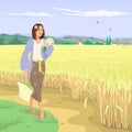 The girl is walking along the wheat field