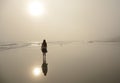 Girl walking on beautiful foggy beach. Royalty Free Stock Photo