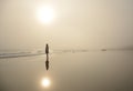 Girl walking on beautiful foggy beach. Royalty Free Stock Photo