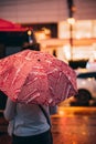 Girl walking in a city, on a rainy night with umbrella and city lights. Royalty Free Stock Photo