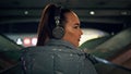 Girl walking dark subway wearing wireless headset closeup. Woman listening music