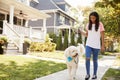 Girl Walking Dog Along Suburban Street Royalty Free Stock Photo