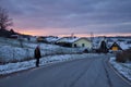 Girl walking down road to German village with colorful sky Royalty Free Stock Photo