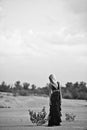 Girl walking in the long black dress in the desert