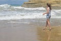 Girl walking and look on the sea waves Royalty Free Stock Photo