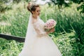 The girl is walking in a lush lace dress in a sleek field with tall grass on her wedding day. A beautiful bunch of spies Royalty Free Stock Photo