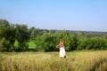Girl walking on the meadow in summer day