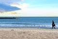 Girl is walking near the sea. Young woman walks along the sand of a beach near Mediterranean Sea Royalty Free Stock Photo