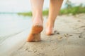 A girl walking on a sandy beach, leaving footprints in the sand. Beach trips. Loneliness. Happiness. Pacification