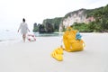 Girl is walking into the sea with yellow bag and shoes on a fore Royalty Free Stock Photo