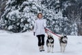 Girl walking with siberian husky in winter forest and park