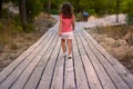 Girl walking on a wooden walkway in the middle of the forest Royalty Free Stock Photo