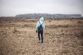 A girl walks across the field. Cut down forest. Royalty Free Stock Photo