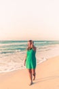 Girl walks along the beach in a dress