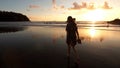 A girl walks along the beach at sunset. Royalty Free Stock Photo