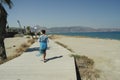 A girl walks along a wooden path along the sea Royalty Free Stock Photo