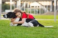 Girl walks with dog in the green grass in summer