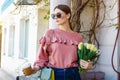 Girl walks down the street with a bouquet of flowers and coffee Royalty Free Stock Photo